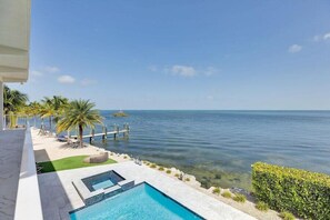 A pool area with clear water, a dock, and a view of the sea. - Gulfside Oasis a Dream on the Gulf (Marathon)