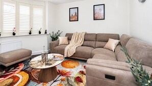 Ein Wohnzimmer mit einer Couch, einem Couchtisch und einem gemusterten Teppich.