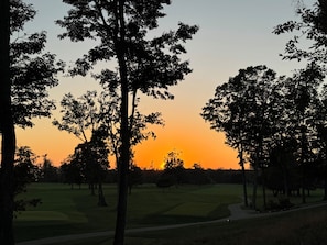 A golf course with trees and a sunset in the background. - Serene 3-bedroom cottage, a children's paradise, Wildflower Schoolhouse. (Harbor Springs)