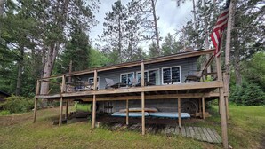Une terrasse en bois à deux niveaux offrant une vue sur la forêt environnante.