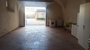 Un pasillo abovedado que conduce a un patio con una lavadora y un radiador.