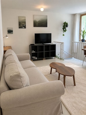 A modern living room with a sofa, a coffee table, a TV, and a bookshelf. - Luxury Two-Story Apartment in the Heart of Stockholm (Stockholm)