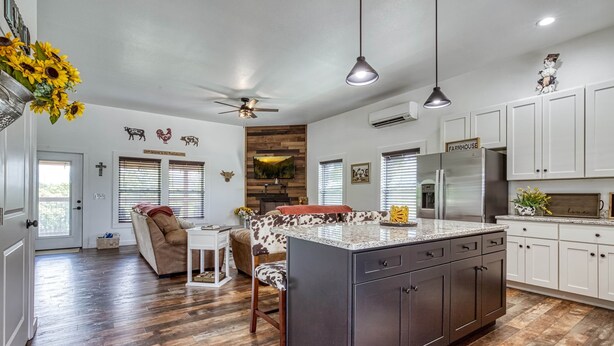 A modern kitchen with a central island, white cabinetry, and a farmhouse-style decor. - Southern Charm (Sevierville)