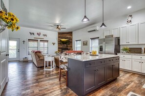 A modern kitchen with a central island, white cabinetry, and a farmhouse-style decor. - Southern Charm (Sevierville)