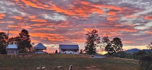 A rural landscape with a gazebo, a barn, and a white car parked on a hill. - Southern Charm (Sevierville)