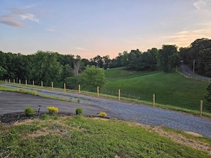 A rural landscape with a paved road, grassy areas, and a fenced field. - Southern Charm (Sevierville)