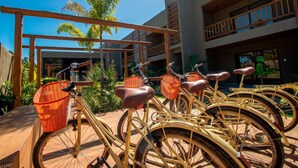A row of bicycles with baskets, a wooden pergola, and a building with balconies. - Azuk Milagres 6 p Close to Patacho Beach by MME (Porto de Pedras)