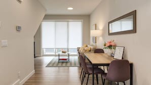 Een moderne eetruimte met een houten tafel, stoelen, een lamp en een bloevas.