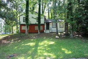 A two-story house with a front door, a small porch, and a garage. - Spacious Southern Charm with Pool Table! (Jonesboro)