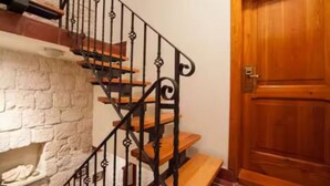 A staircase with a wrought iron railing, wooden steps, and a white brick wall. - Four Bedroom House with Terrace (Komiza)