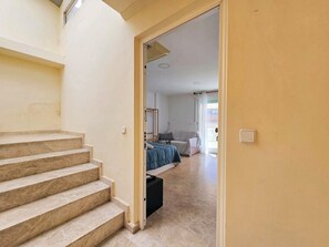 A staircase leading to a bedroom with a bed, a bedside table, and a window. - Ático A - Cartagena Centro histórico by Interhome (Cartagena)