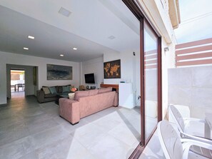 A modern living room with a large sofa, a flat-screen TV, and a world map on the wall. - Sweet Home Cabo de Palos by Interhome (Cabo de Palos)