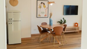 A dining area with a wooden table, chairs, a vase, and a television on the wall. - 2-bedroom apartment with lakeview in beautiful Brenzone sul Garda with AC (Brenzone sul Garda)