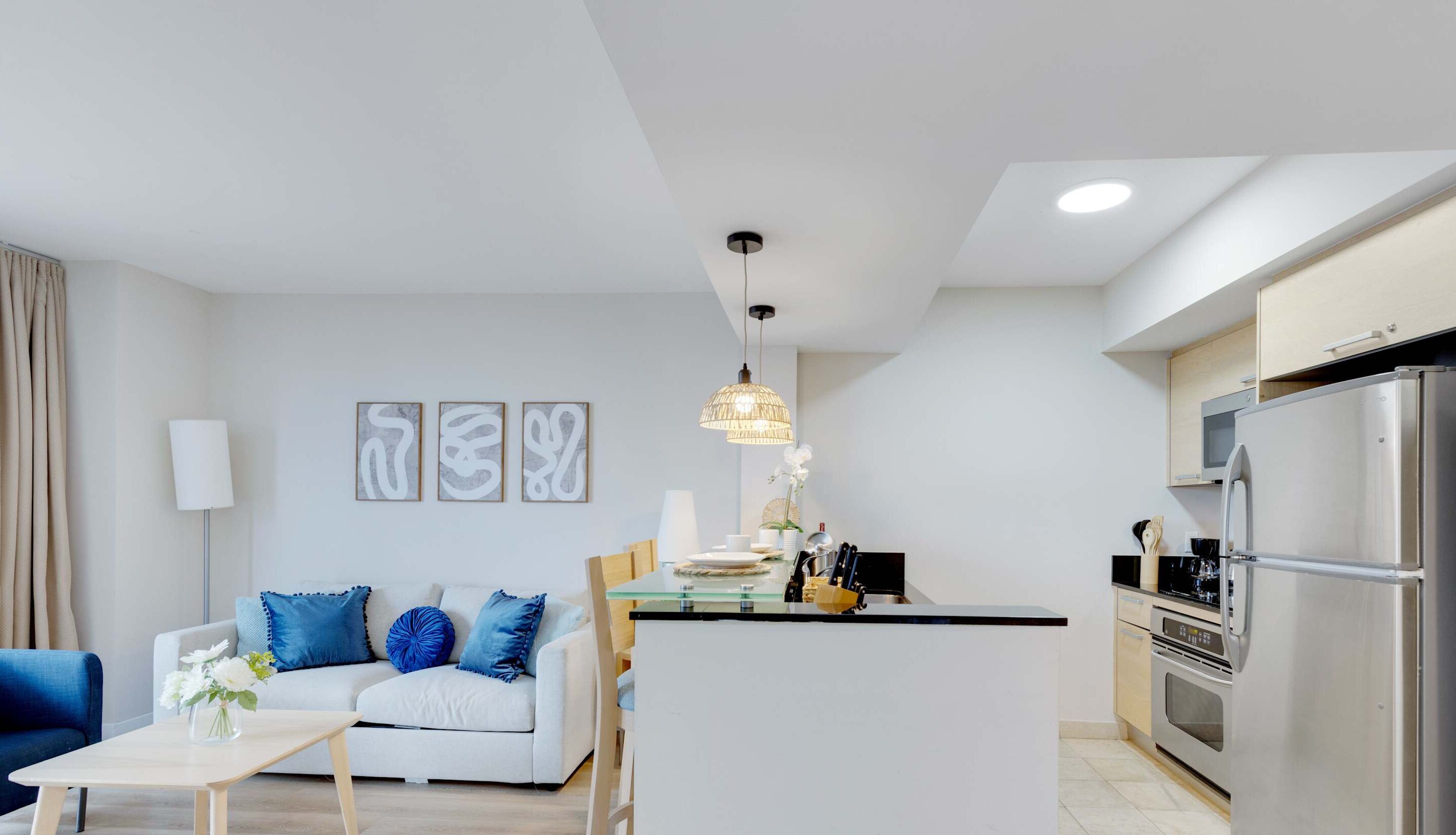 Een moderne woonkamer met een bank, salontafel en kunstwerk aan de muur.