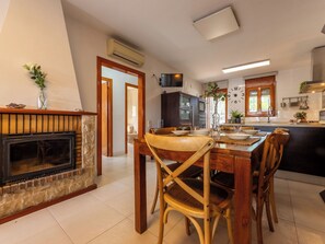 Eine moderne Küche mit Essbereich, Kamin und Blick zum Wohnzimmer.