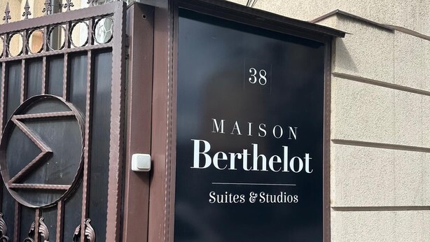 Une enseigne pour « Maison Berthelot Suites & Studios », au numéro 38, avec un portail en métal et des éléments décoratifs en fer forgé.