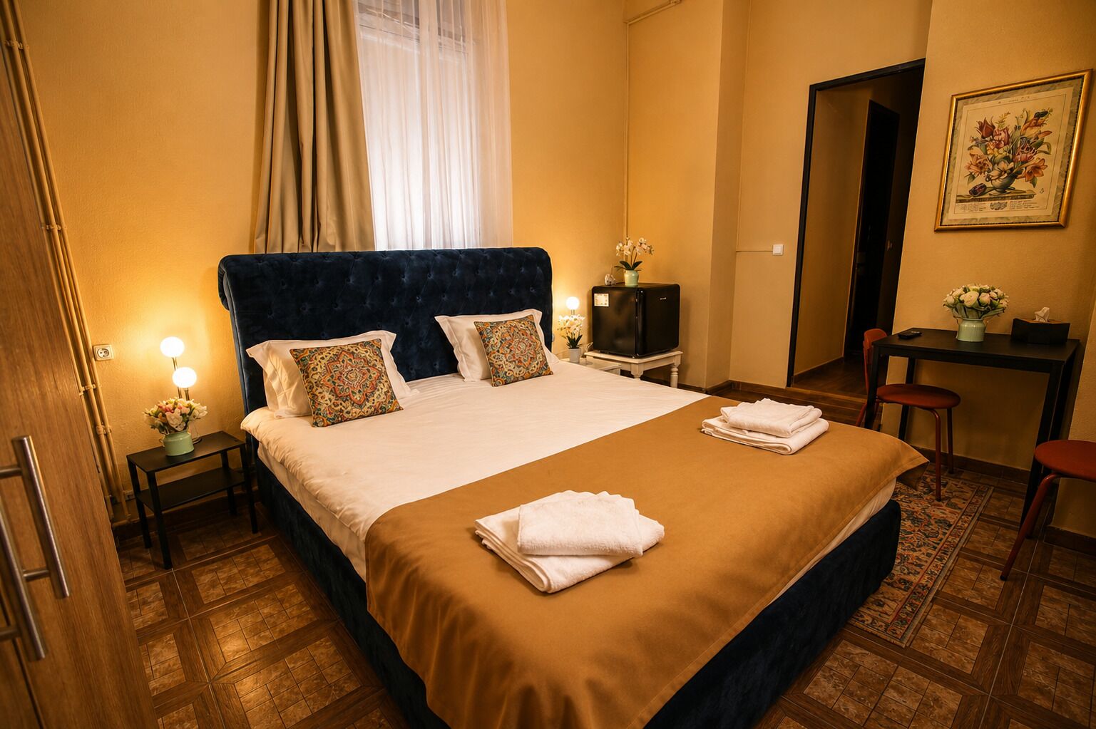 Ein Hotelzimmer mit einem Bett, Nachttischen, einem Schreibtisch und einem Stuhl.