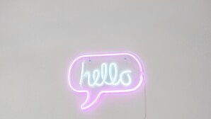 Um letreiro de neon com a palavra 'hello' em formato de balão de diálogo.