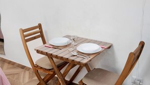 Uma mesa de jantar com duas cadeiras, um copo e talheres.