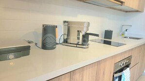 A modern kitchen with a coffee machine, a toaster, and a dishwasher. - Rbk Estudio exclusivo sector Las Condes (Las Condes)