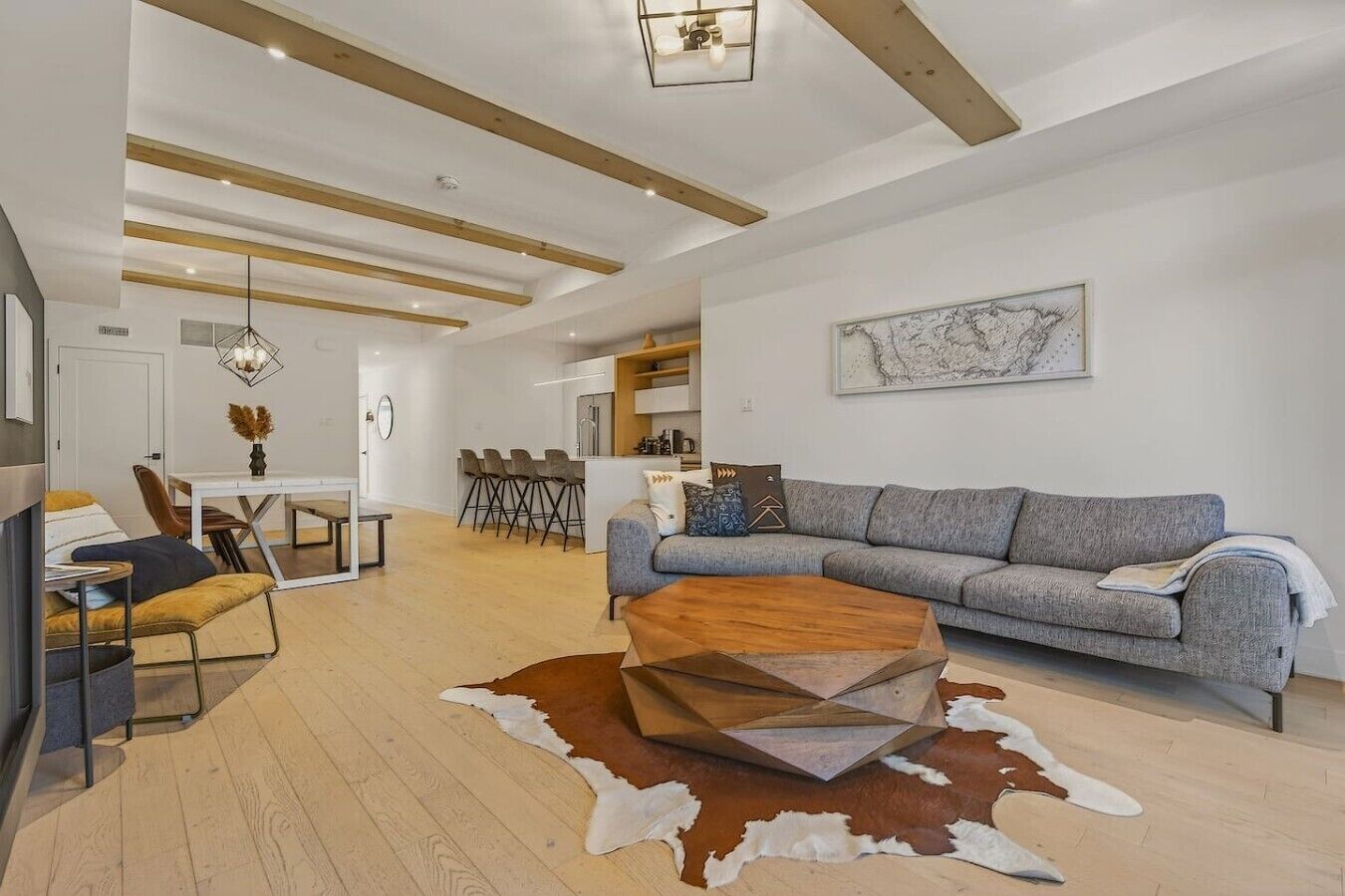 Uma sala de estar moderna com sofá, mesa de centro e área de jantar.