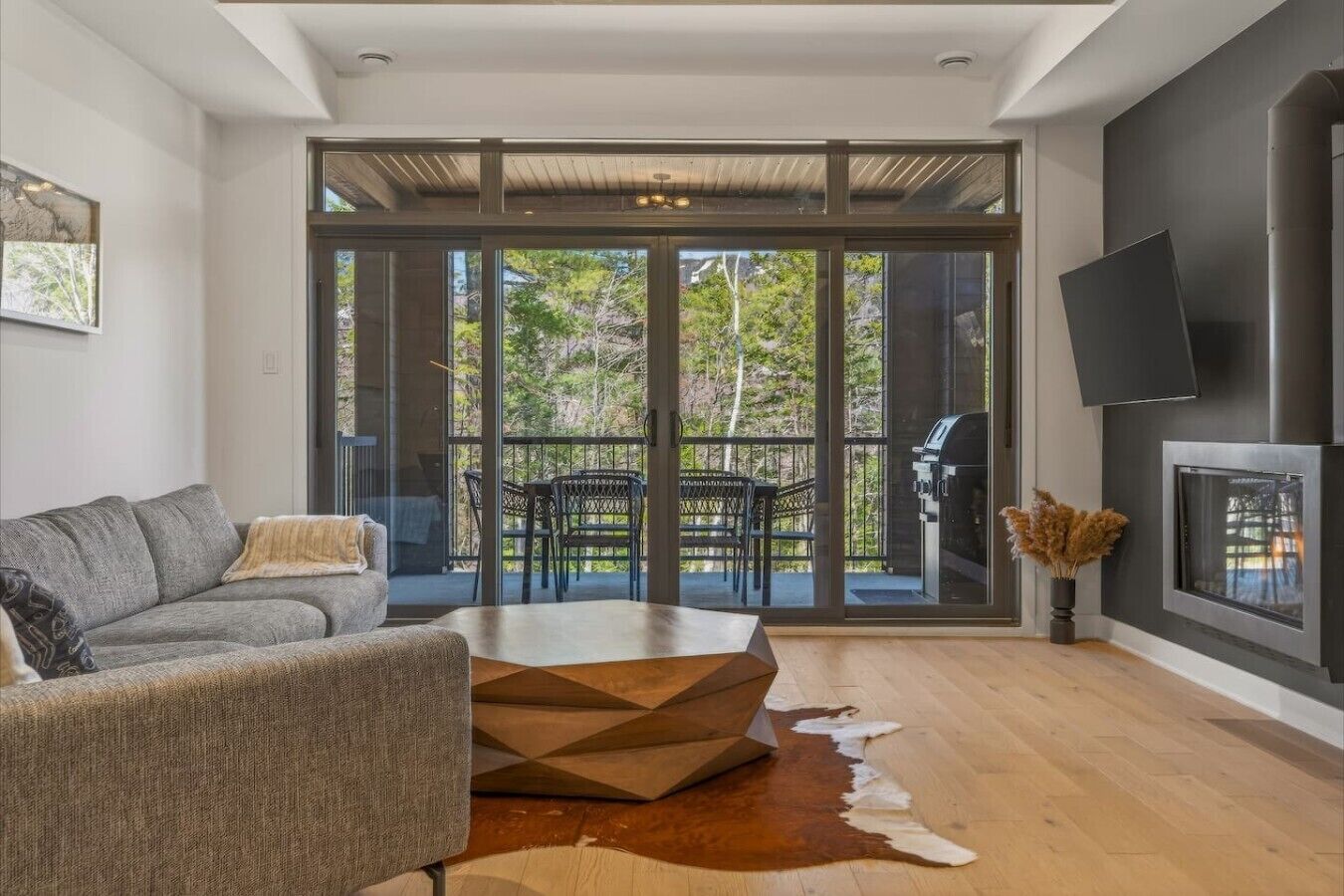 Un salon moderne avec un canapé, une table basse et une cheminée.