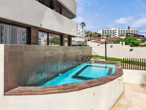 A modern building with a swimming pool, a restaurant sign, and a view of other buildings. - Abedules by Interhome (Benalmádena Costa)