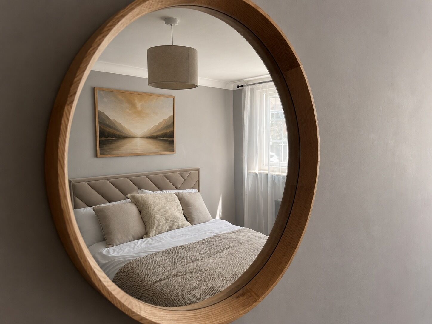 A bedroom with a bed, a painting, and a window.