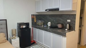 A compact kitchen with a microwave, toaster, kettle, and a coffee maker. - Soothing studio with AC in lovely Olongapo City (Olongapo City)