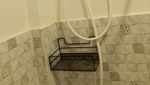 A shower with a control panel, a handheld showerhead, and a black metal shelf. - Soothing studio with AC in lovely Olongapo City (Olongapo City)