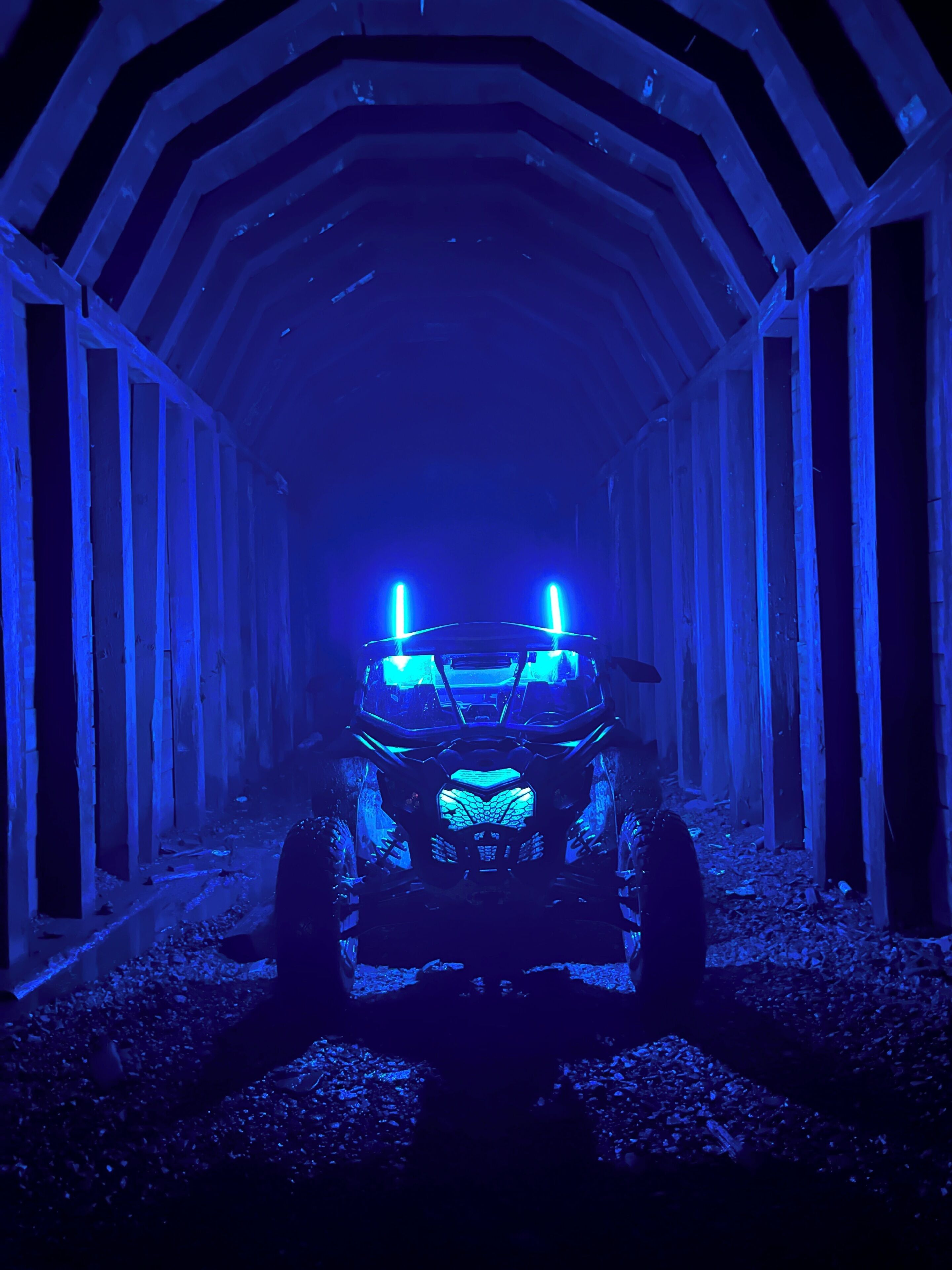 Een voertuig in een tunnel met blauwe verlichting.