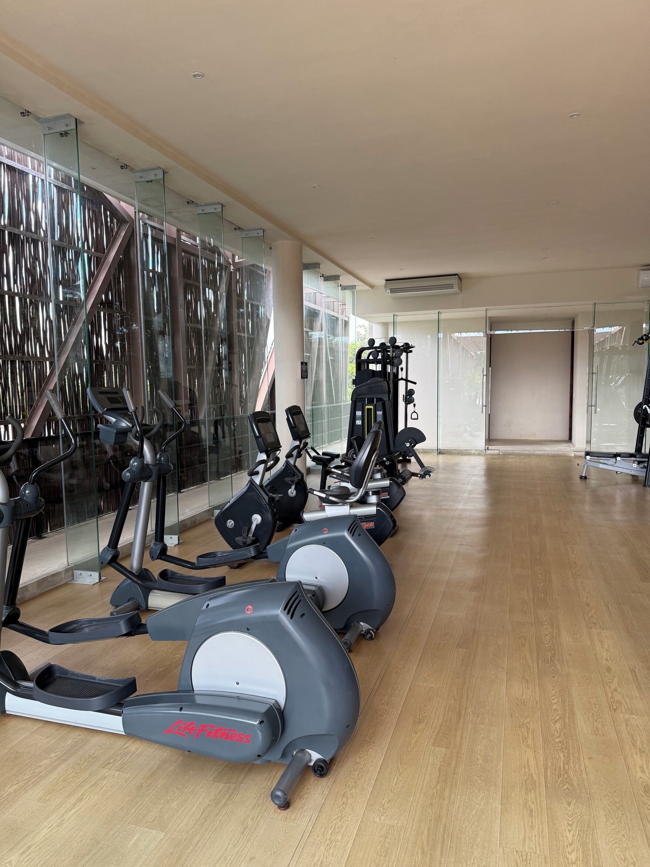 A gym with cardio machines, weight machines, and a mirrored wall.