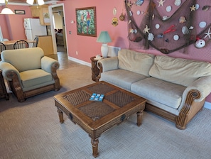 A living room with a sofa, armchair, and coffee table. - Cute Beachy Bungalow-walking distance to beach-3 bd/2 ba house in NMB (North Myrtle Beach)