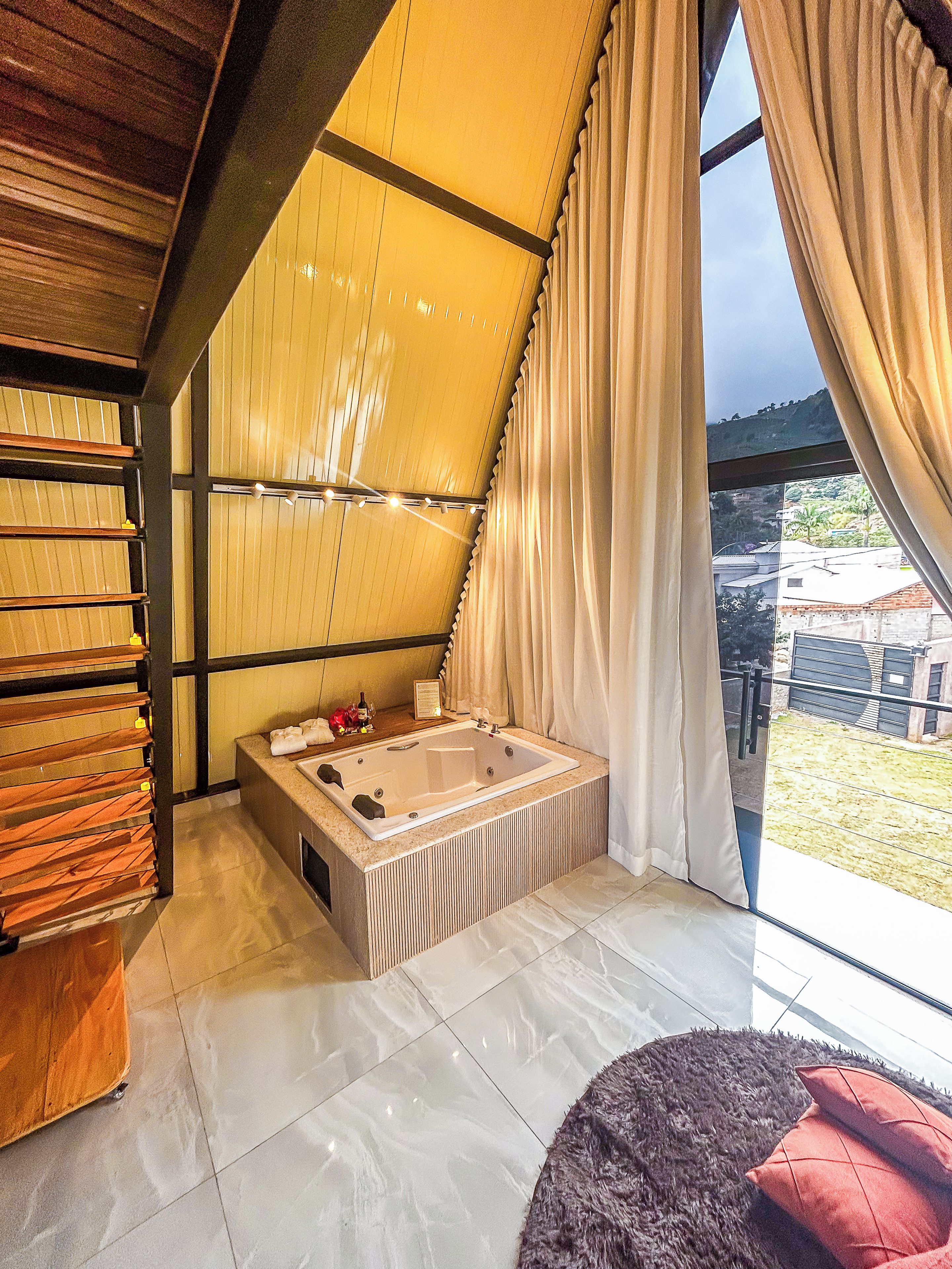 Une salle de bain moderne avec une grande baignoire, des étagères en bois et une vue sur l’extérieur.