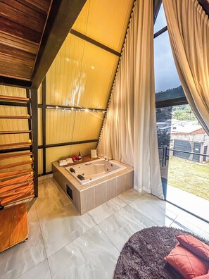 A modern bathroom with a large bathtub, wooden shelves, and a view of the outdoors.