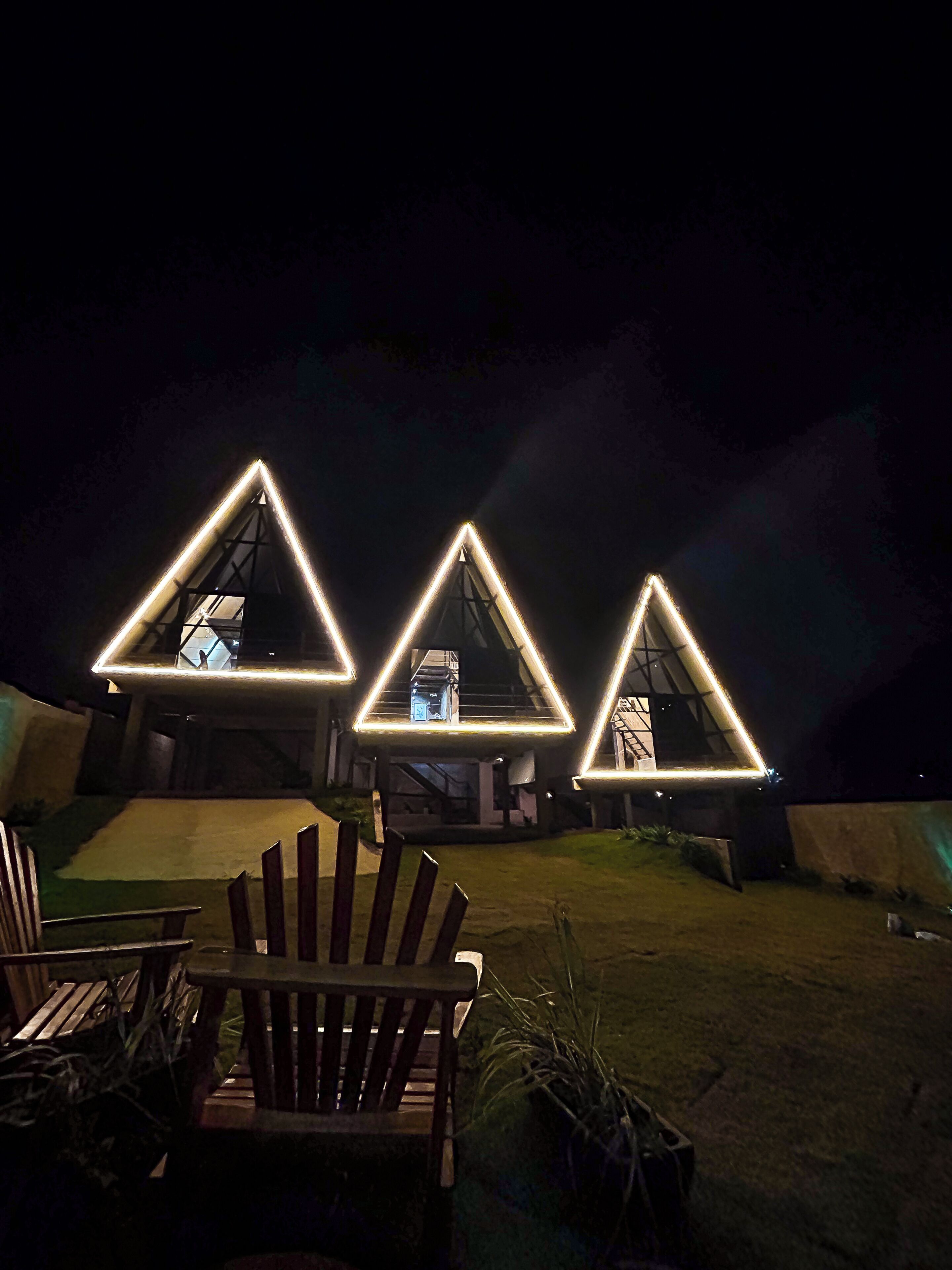 A nighttime view of a building with illuminated triangular structures.