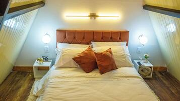 Une chambre à coucher avec un grand lit, deux tables de chevet et un luminaire fixé au mur.