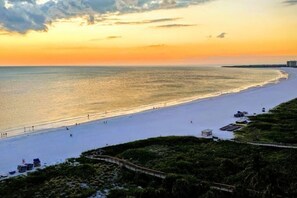 Una spiaggia con cielo sereno e un tramonto.