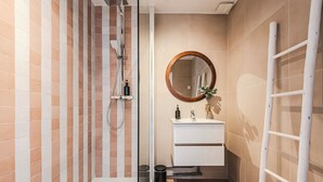 A bathroom with a shower, a sink with a mirror, and a towel rack. - Le Grandval - Spacious 3 rooms (Reims)