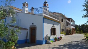 Un edificio tradicional con fachada blanca, detalles azules y tejado de tejas.