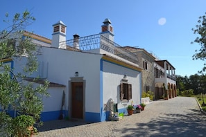 A traditional building with a white facade, blue trim, and a tiled roof.