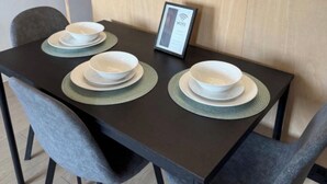 A dining table with a framed WiFi sign, two chairs, and stacked plates. - 2 BEDROOM 2.5 BATHROOM - MODERN - OLD TRAFFORD - CITY CENTRE (Manchester)