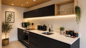 A modern kitchen with black cabinets, a white countertop, a built-in oven, and a coffee station. - 2 BEDROOM 2.5 BATHROOM - MODERN - OLD TRAFFORD - CITY CENTRE (Manchester)