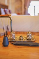 A table with a tray holding two glass teapots and a small vase with reeds.