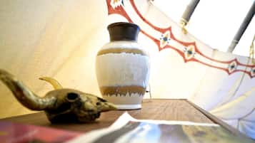 A tent interior with a decorative vase and a skull on a table.
