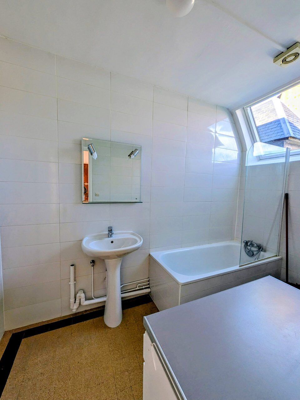 Un baño con lavabo, espejo y bañera.