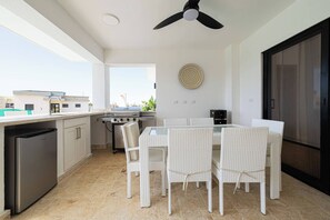 A modern kitchen with a dining area, a ceiling fan, and a view of the outside. - Luxe Villa in the Caribbean Gated Pool & Sun (Sosúa)
