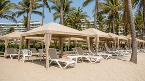 A beach with sun umbrellas, lounge chairs, and palm trees. - Depto. Playa & Piscina Acapulco 4 Rec (Acapulco de Juarez)