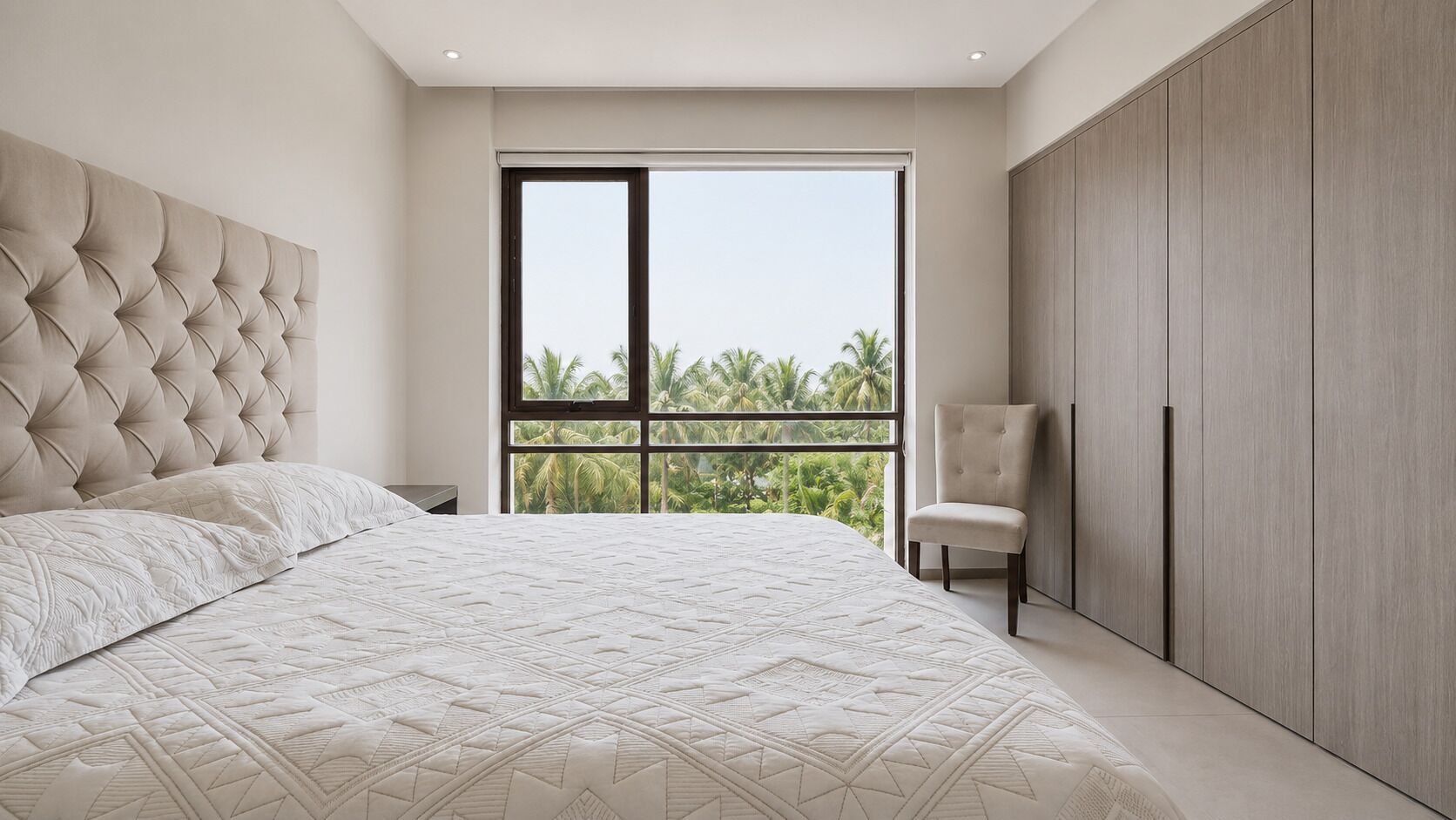 Un dormitorio con una cama grande, una silla, un armario y vistas a palmeras a través de una ventana.