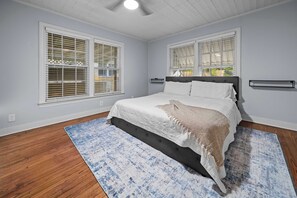 A bedroom with a bed, two windows with blinds, a ceiling light, and a wooden floor. - Jarrel Cottage Longer Stays Welcome! (Tyler)